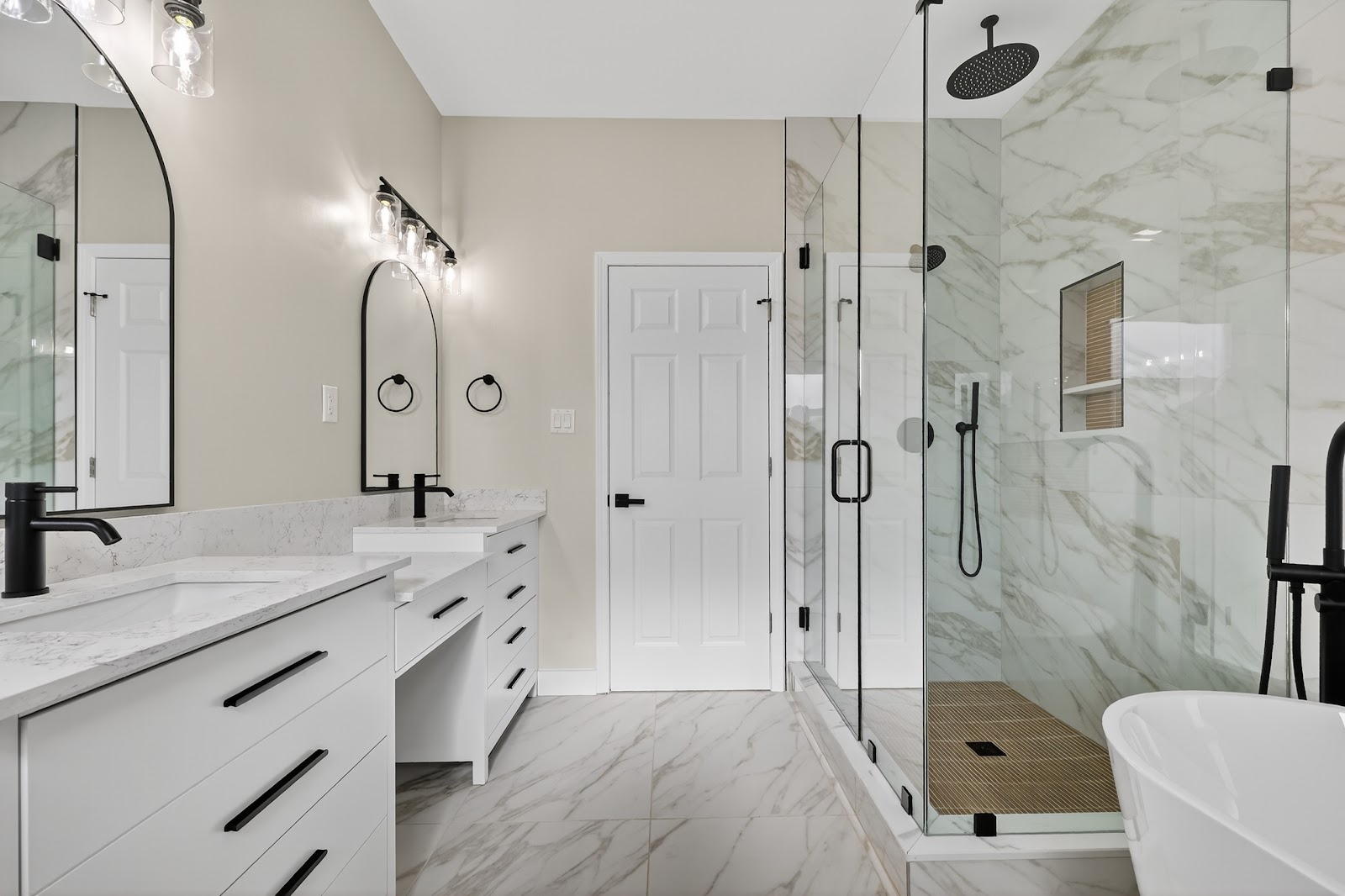 A finished bathroom remodel with a glass shower, a double vanity and a soaking tub
