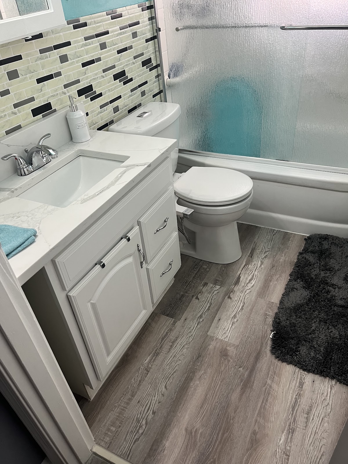 A refreshed bathroom with a new vanity, toilet and tub