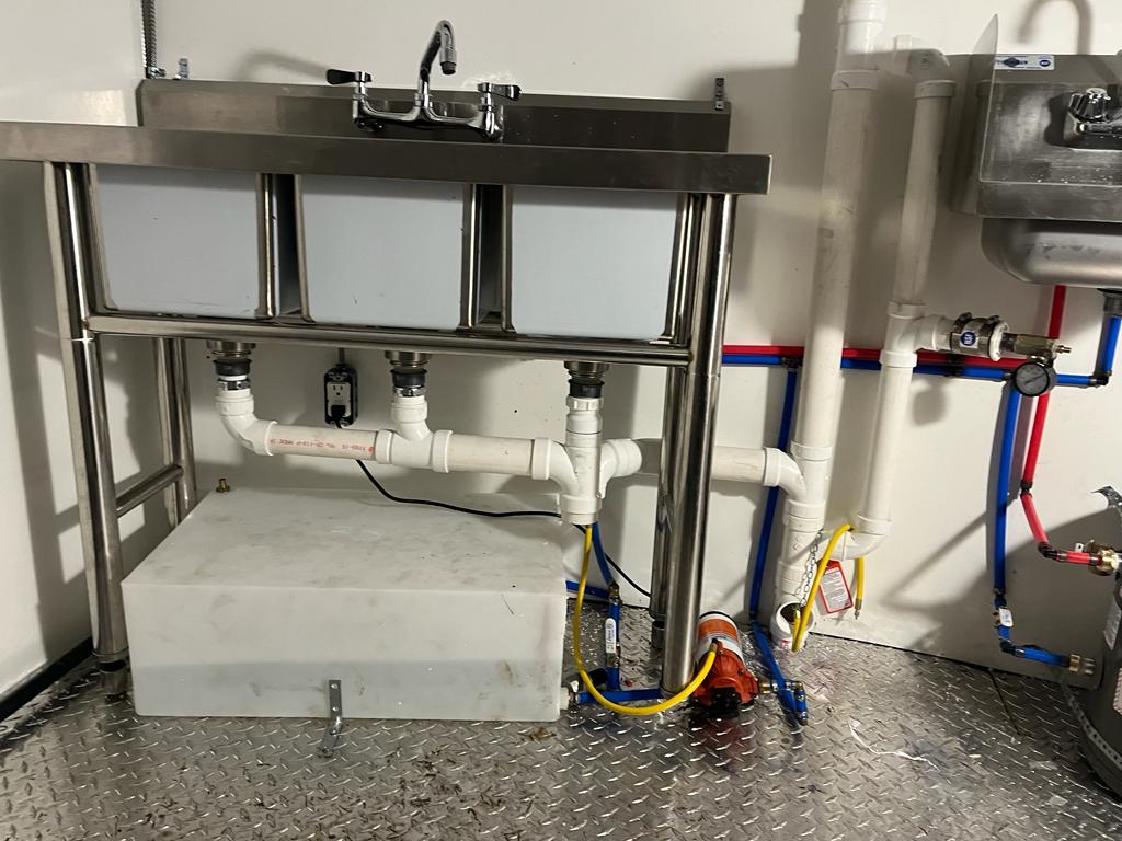 A commercial three bay sink with new drains and supply lines