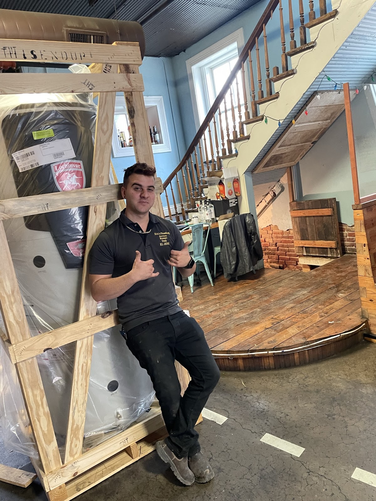Dany with a new water heater still in its crate, ready to go in