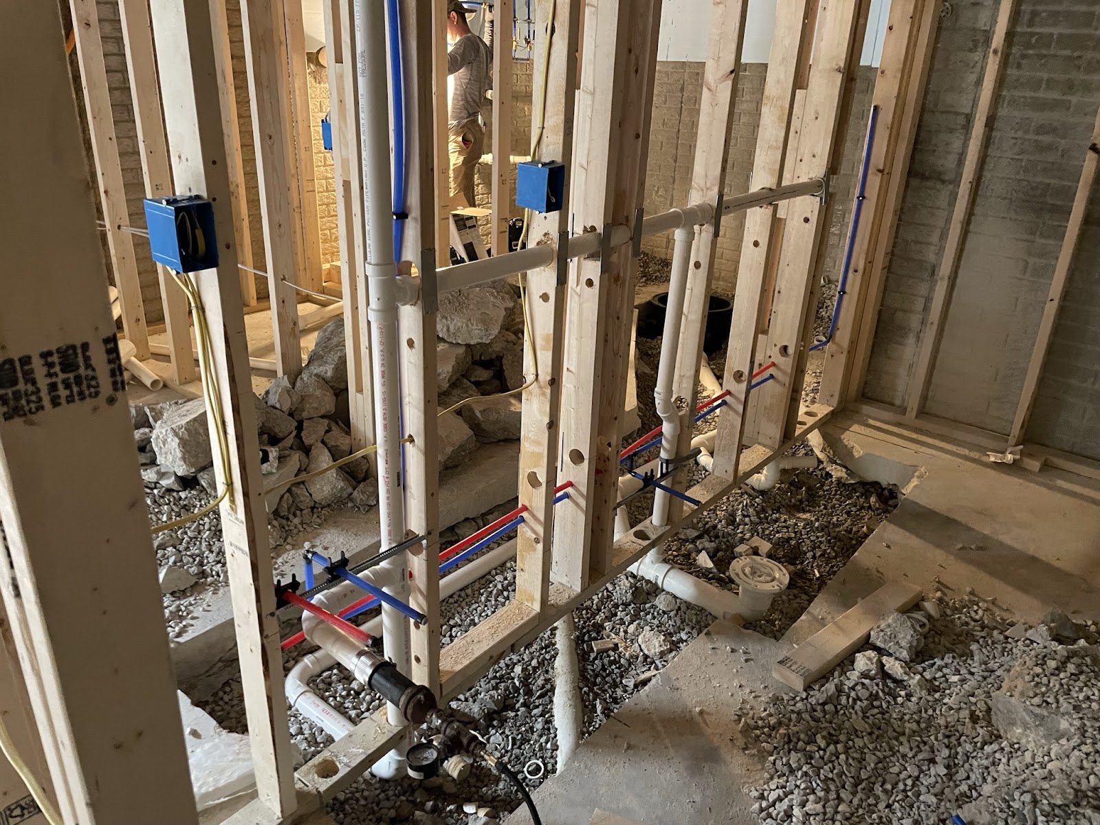 New water and drain lines run through fresh framing on a new build