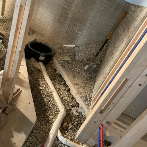 A new sewer line laid in an open trench under a slab